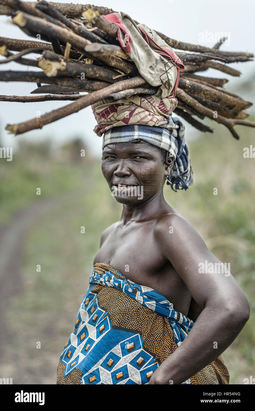 Portrait of a woman from the Holi tribe carrying a load on her head. In Africa many things are still carried on the heads since not everyone has a mot Stock Photo