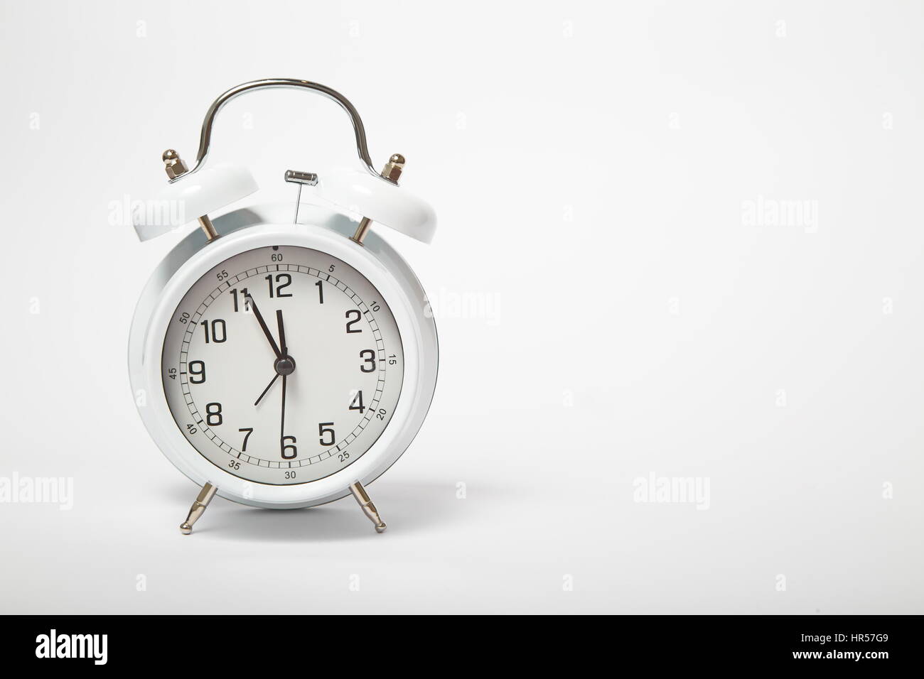 Big old vintage alarm clock with bells on white bacgrkound Stock Photo