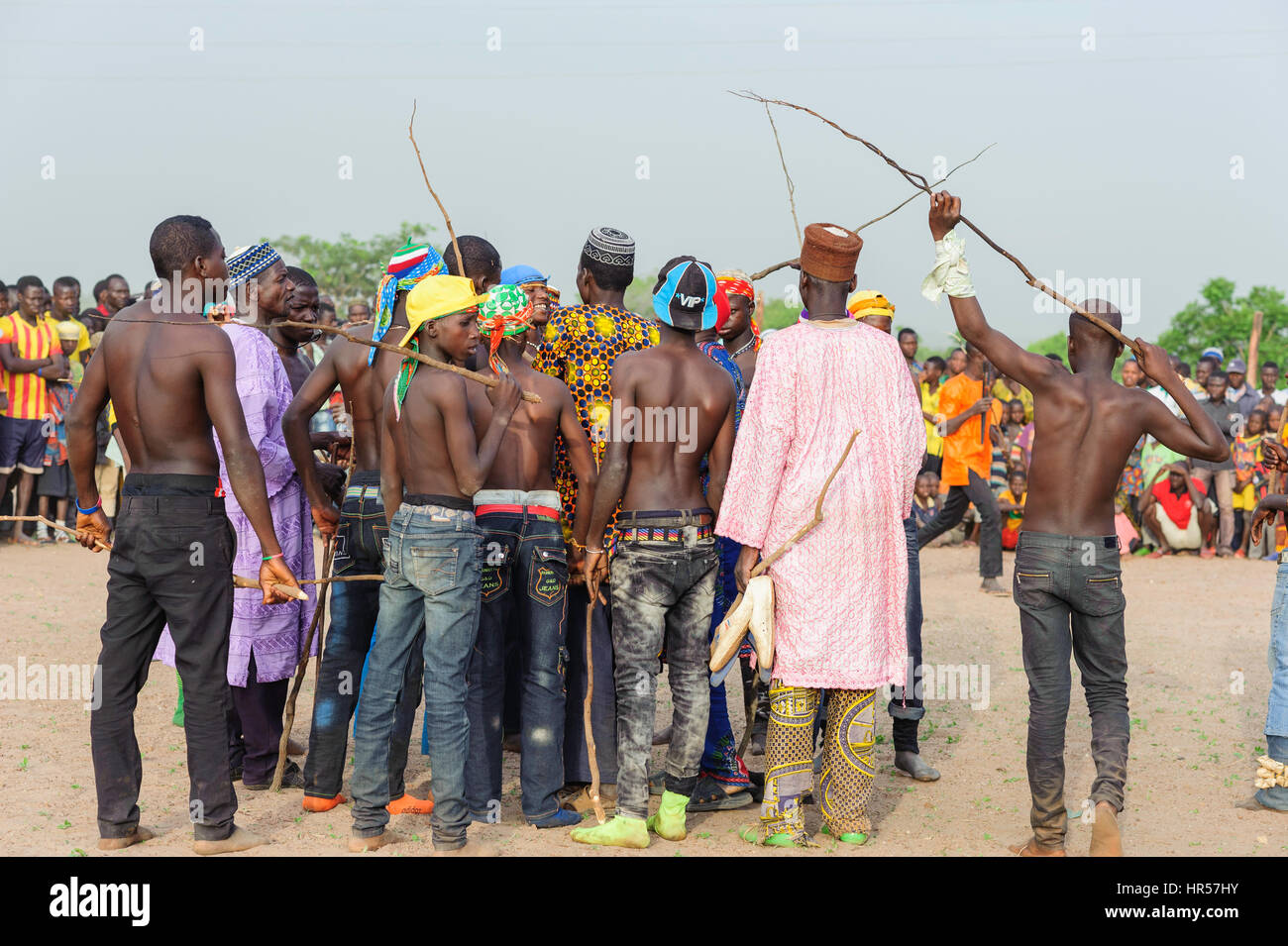 Fulani boys with sticks in their hands waiting in the fighting pit for the combats to start. Becoming a man for the Fulani boys of Benin is not an eas Stock Photo