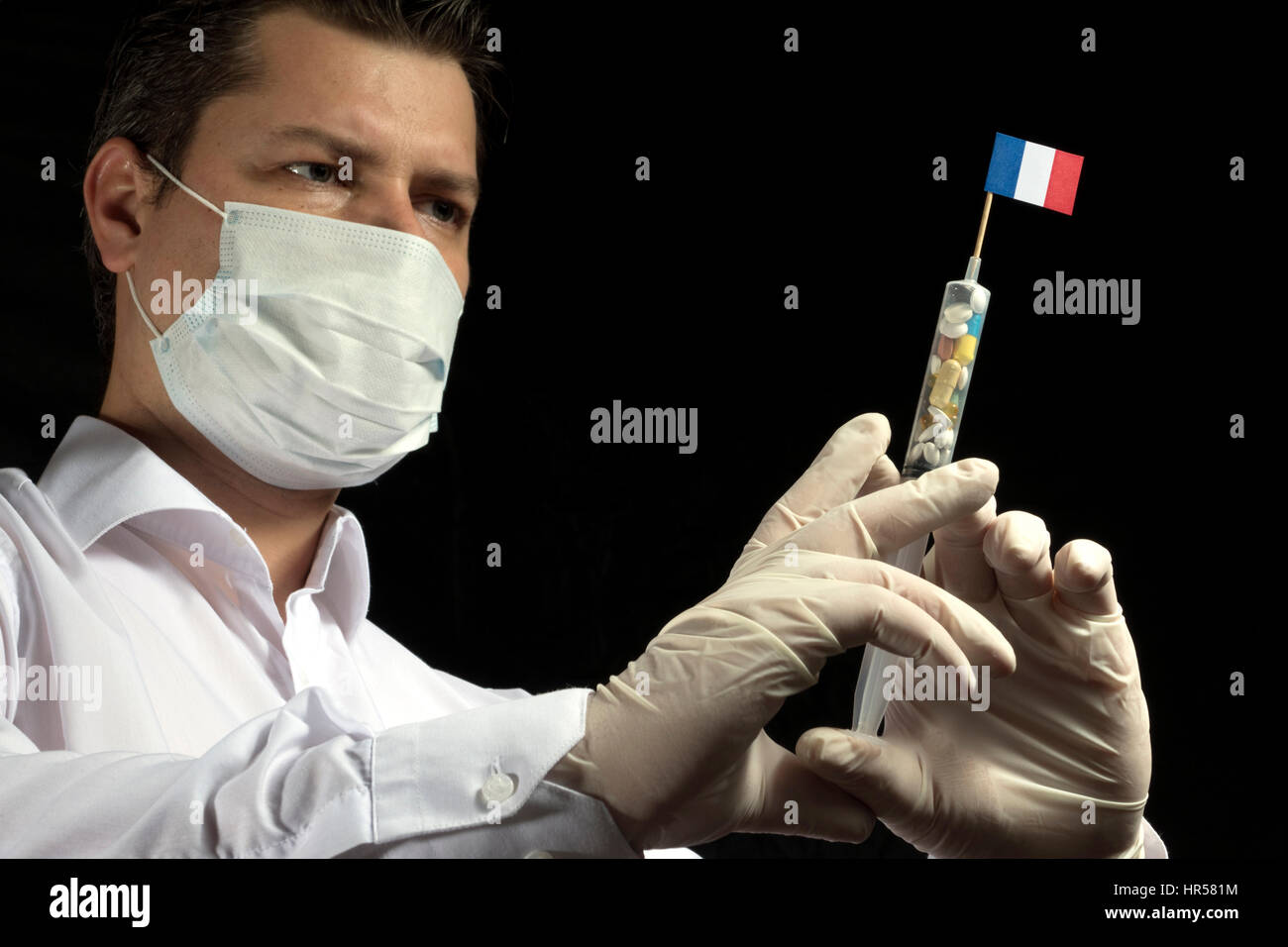 Young man as a doctor gives a medical injection to French flag on a ...