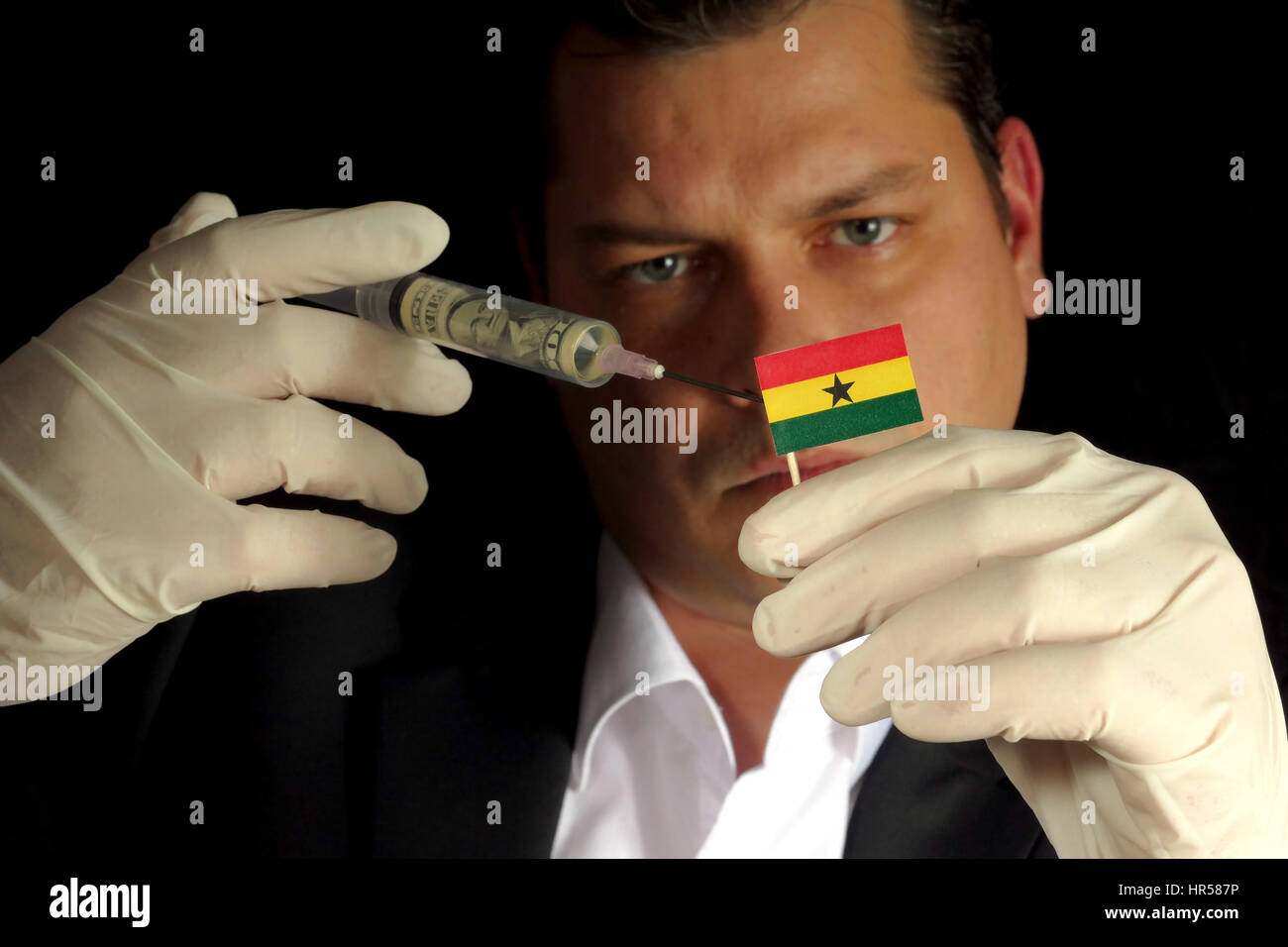 Fiscal Injection Young businessman gives a financial injection to Ghanaian flag isolated ...