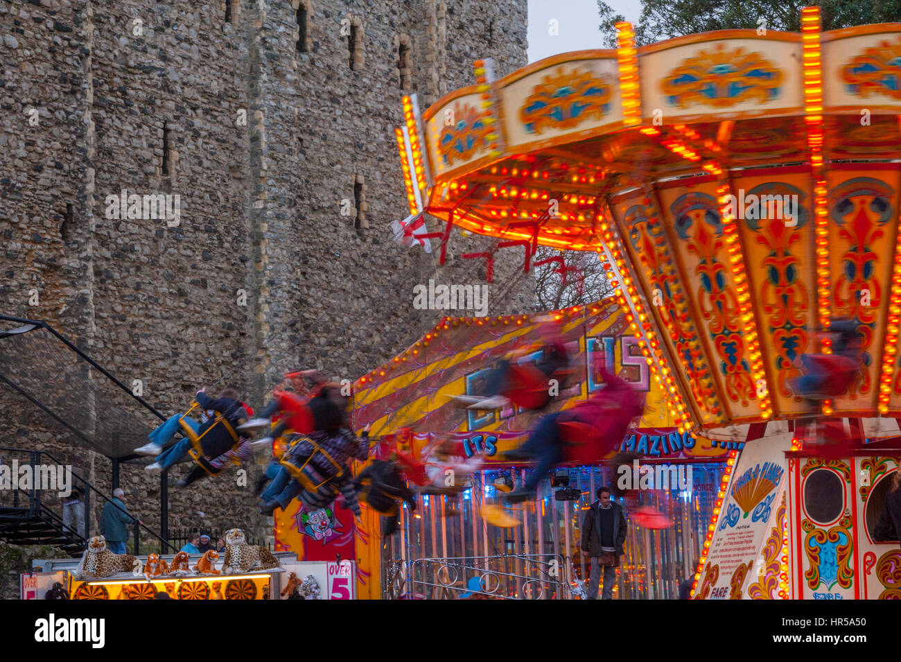 Fairground ride in the grounds of Rochester castle during Sweeps street festival. Stock Photo