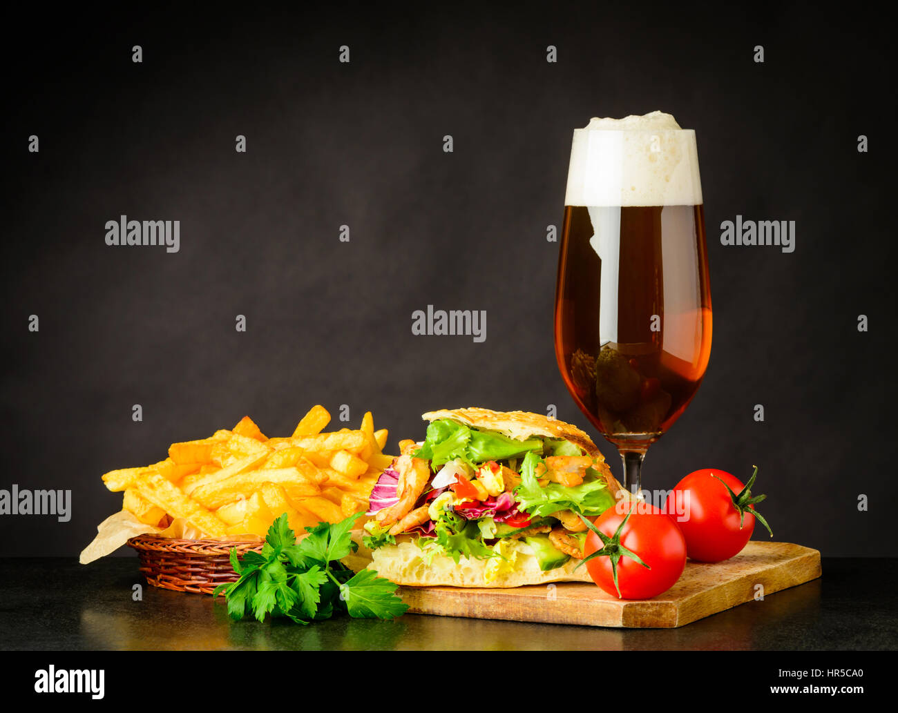 French Fries and Doner Kebap Sandwich with Glass Beer and Fresh Vegetables Stock Photo