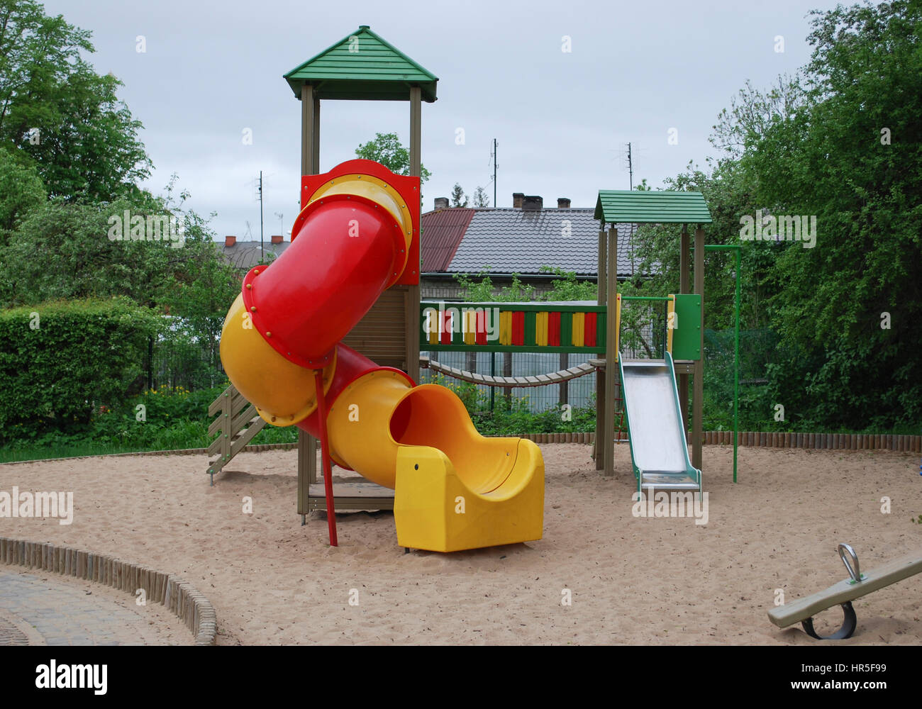 Children’s multi colors playground in public park. Bridge, stairs, slide, platforms. Place for games and sports activities. Stock Photo