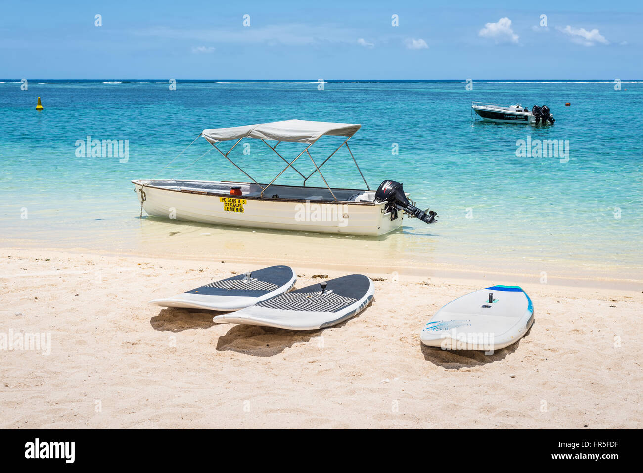 Le Morne, Mauritius - December 7, 2015: Windsurfing boards and boats on the Le Morne Beach, one of the finest beaches in Mauritius and the site of man Stock Photo