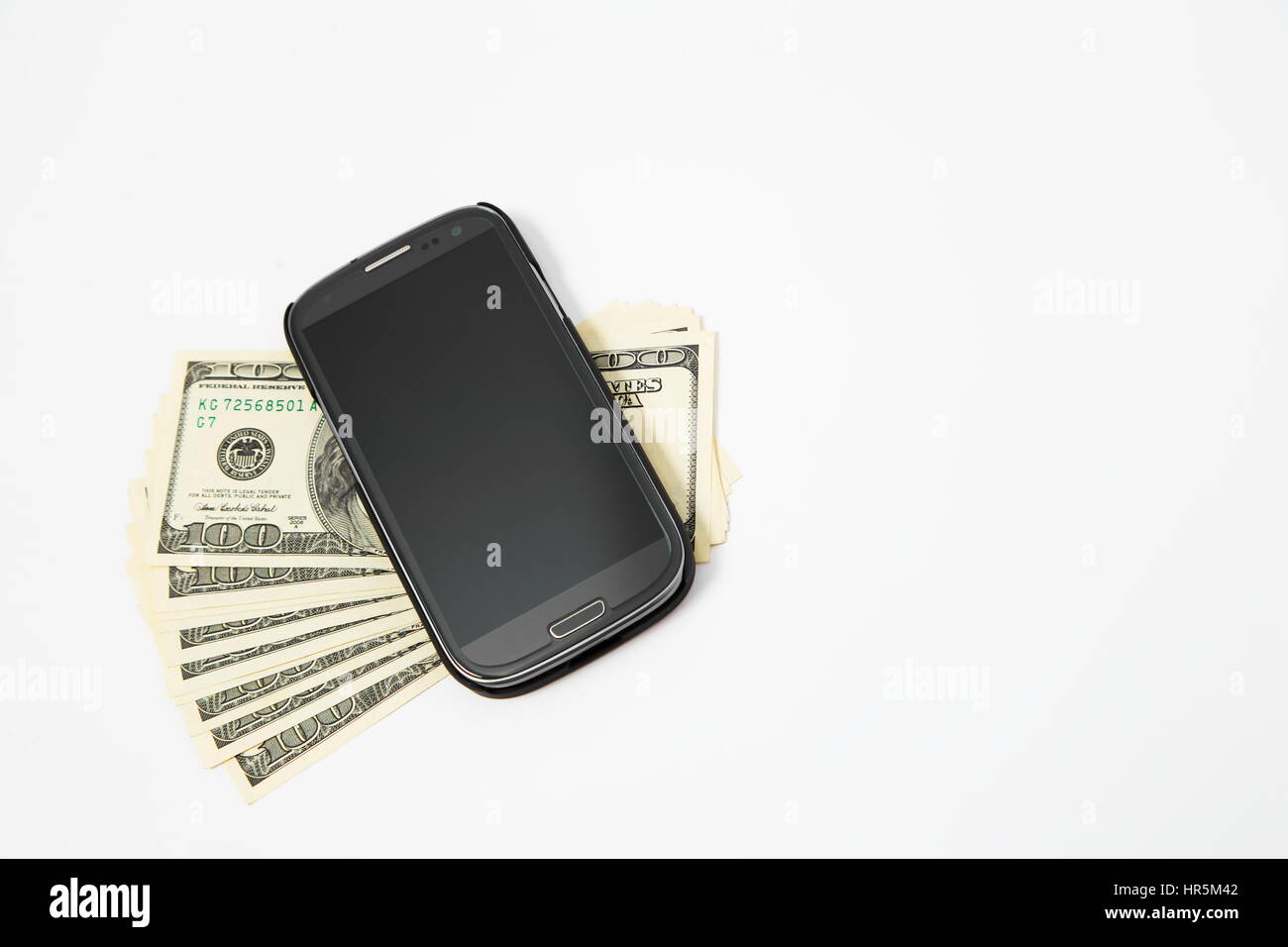 Smartphone lying on the United States dollars, isolated on a white background Stock Photo