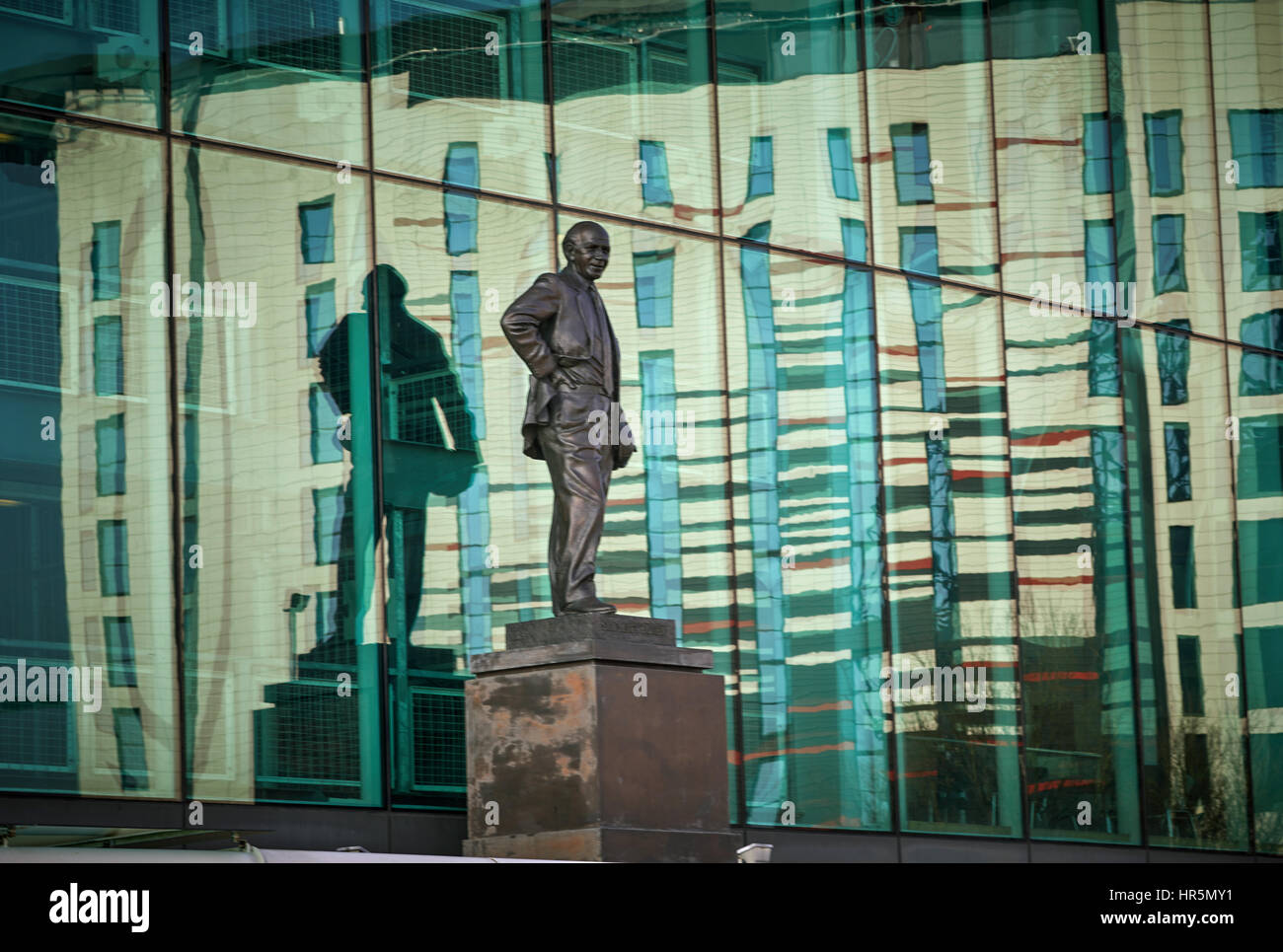 Hotel Football reflects in the glass Sir Matt Busby statue at Old Trafford Stadium Manchester England,UK Stock Photo