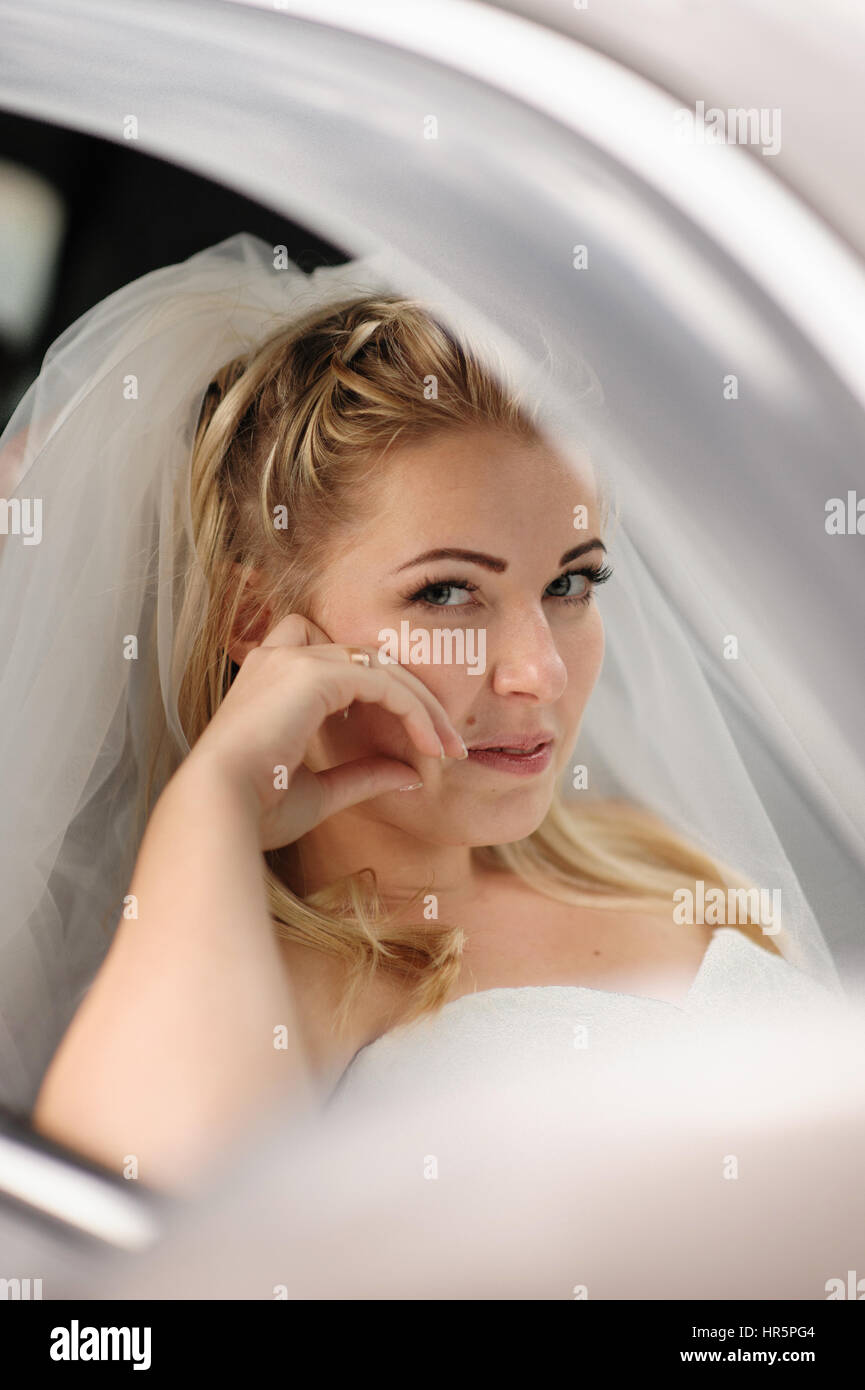 happy bride sitting in the wedding car. Stock Photo