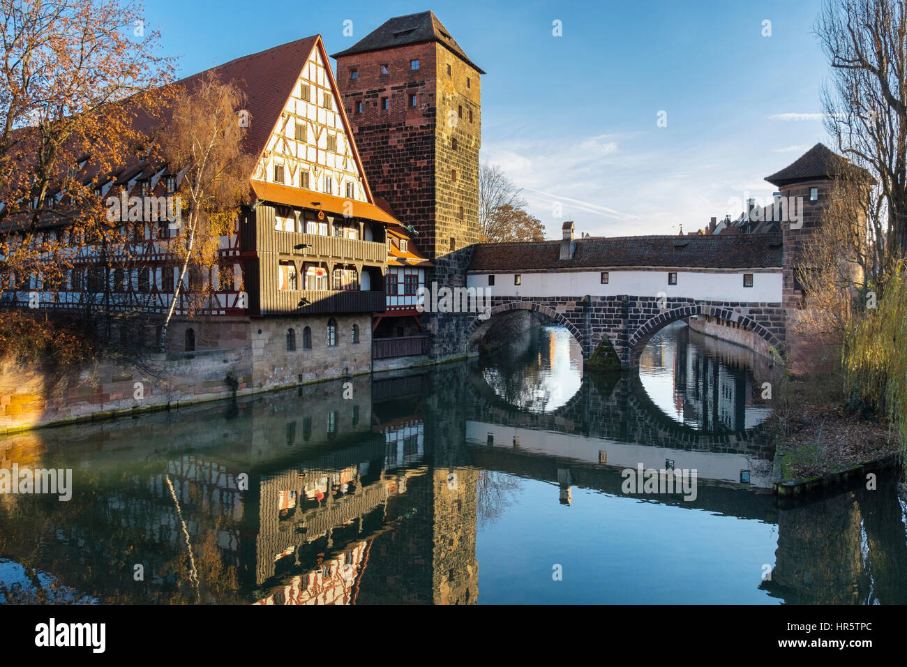 15th century old Weinstadle timbered building and Henkersteg or Hangman's Bridge reflected in Pegnitz River in Nuremberg (Nurnberg), Bavaria, Germany Stock Photo