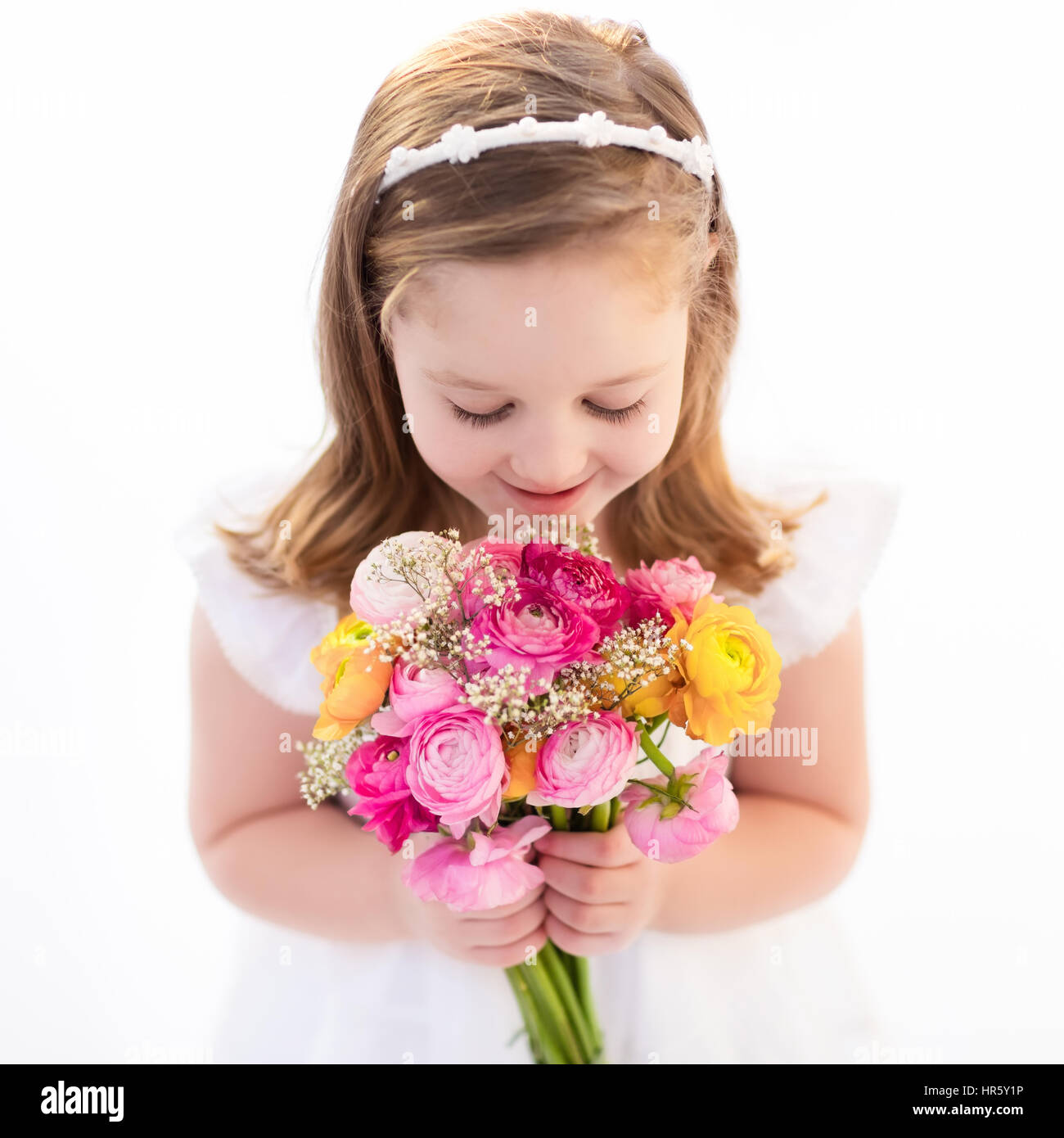 Cute little girl in white dress holding ranunculus flowers bouquet ...