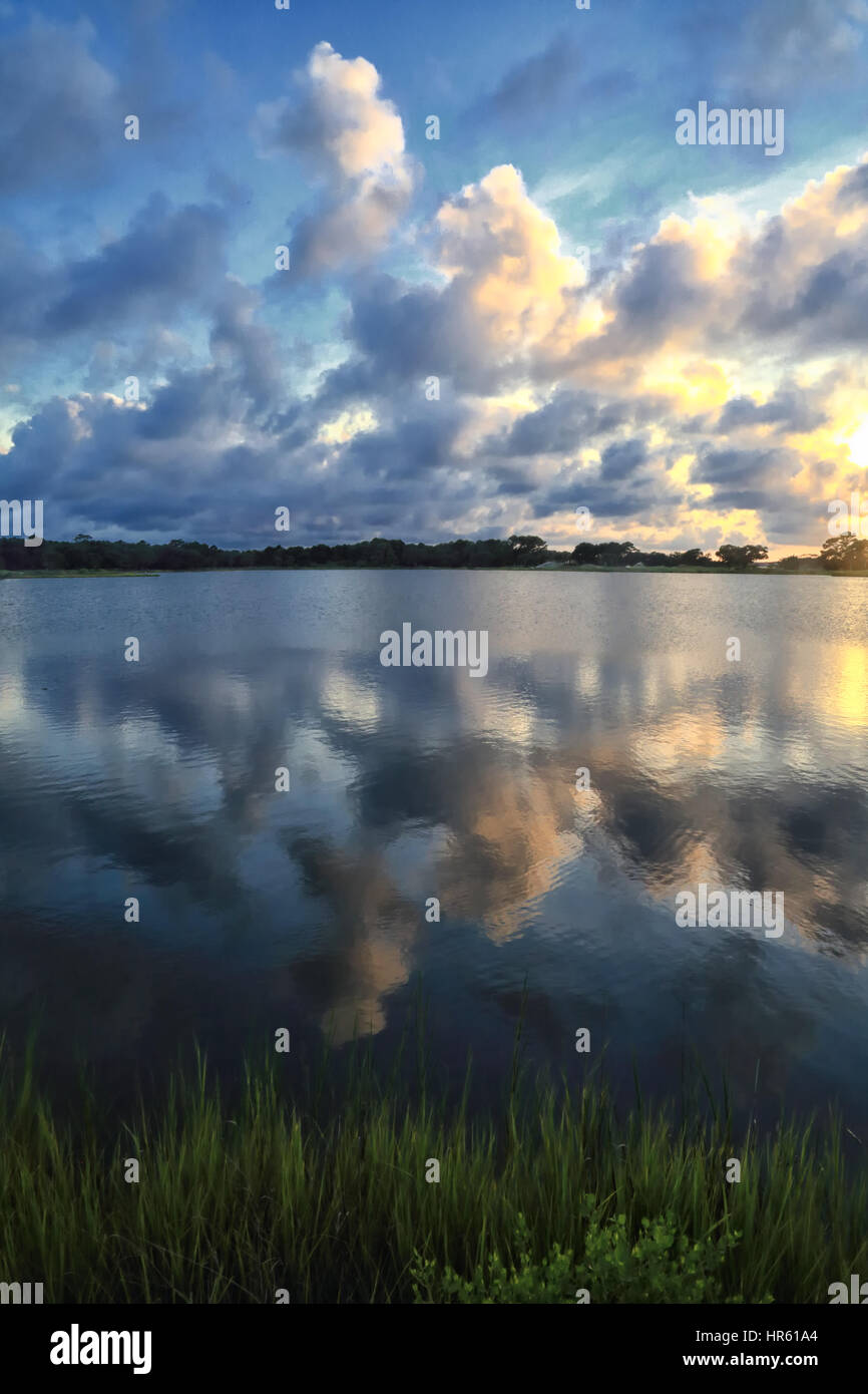 Dramatic storm clouds hover over Bass Pond on Kiawah Island, South Carolina. The clouds are reflected in the pond. Stock Photo