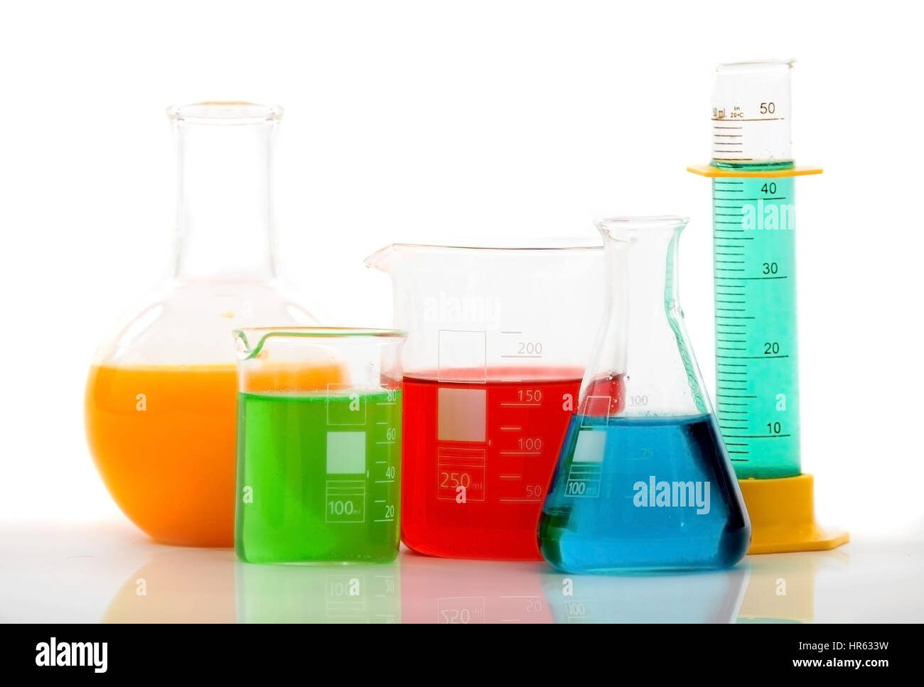 chemistry bottles with different colour liquid inside over a white