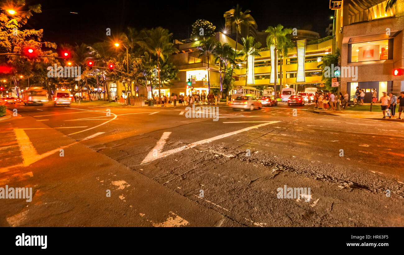 Waikiki crossroad at night. People moving for shopping and cars