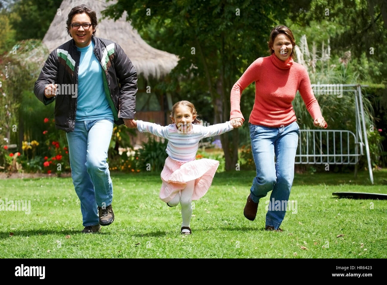 happy family smiling and running outdoors towards the camera Stock Photo