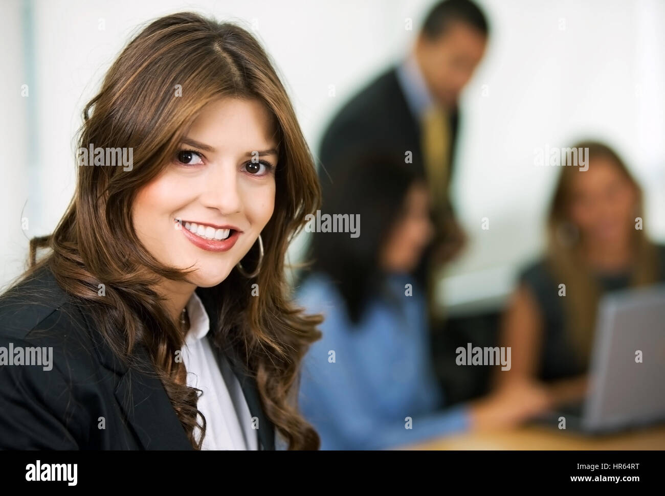 business woman leading a team in an office smiling Stock Photo - Alamy