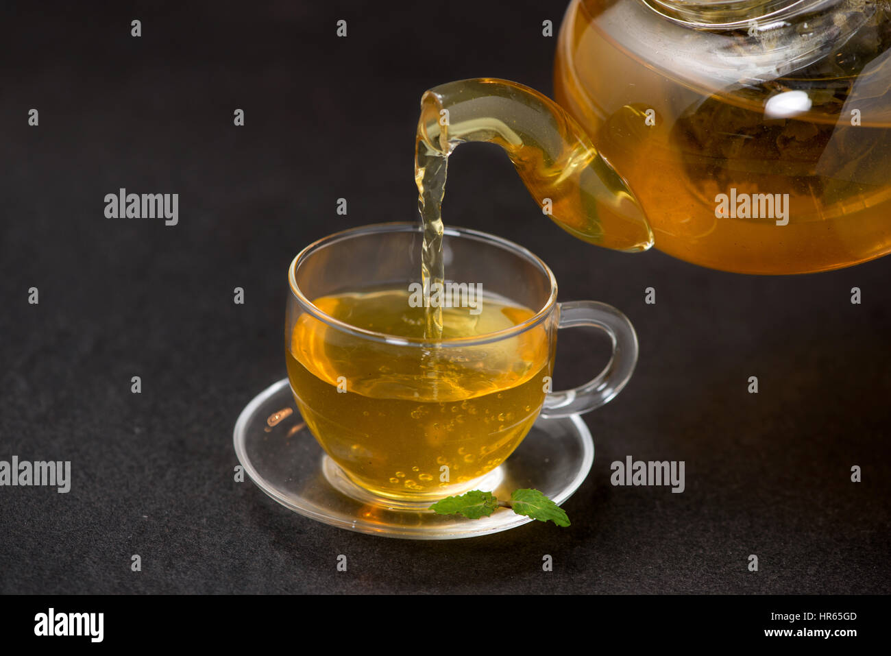 teapot pouring tea into flying cups, on white background Stock Photo