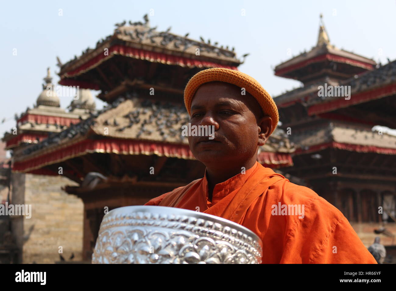A Buddhist man standing in front of temples in Kathmandu Durbar Square.  Kathmandu Durbar Square is old royal palace of former Kathmandu kingdom. Stock Photo