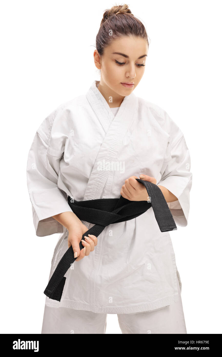 Karate girl tying a black belt isolated on white background Stock Photo