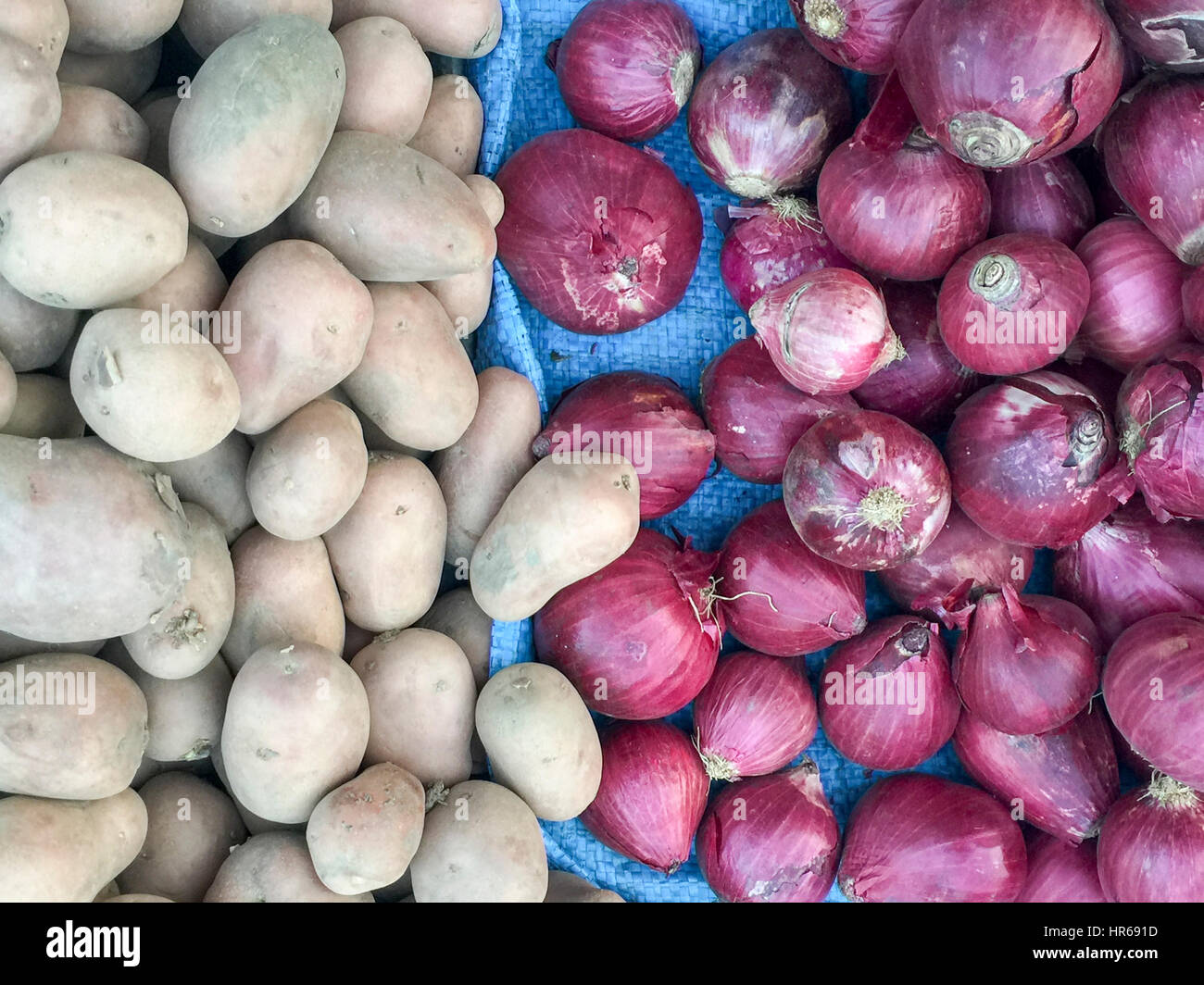 Fresh red onions and potatoes on market display Stock Photo - Alamy