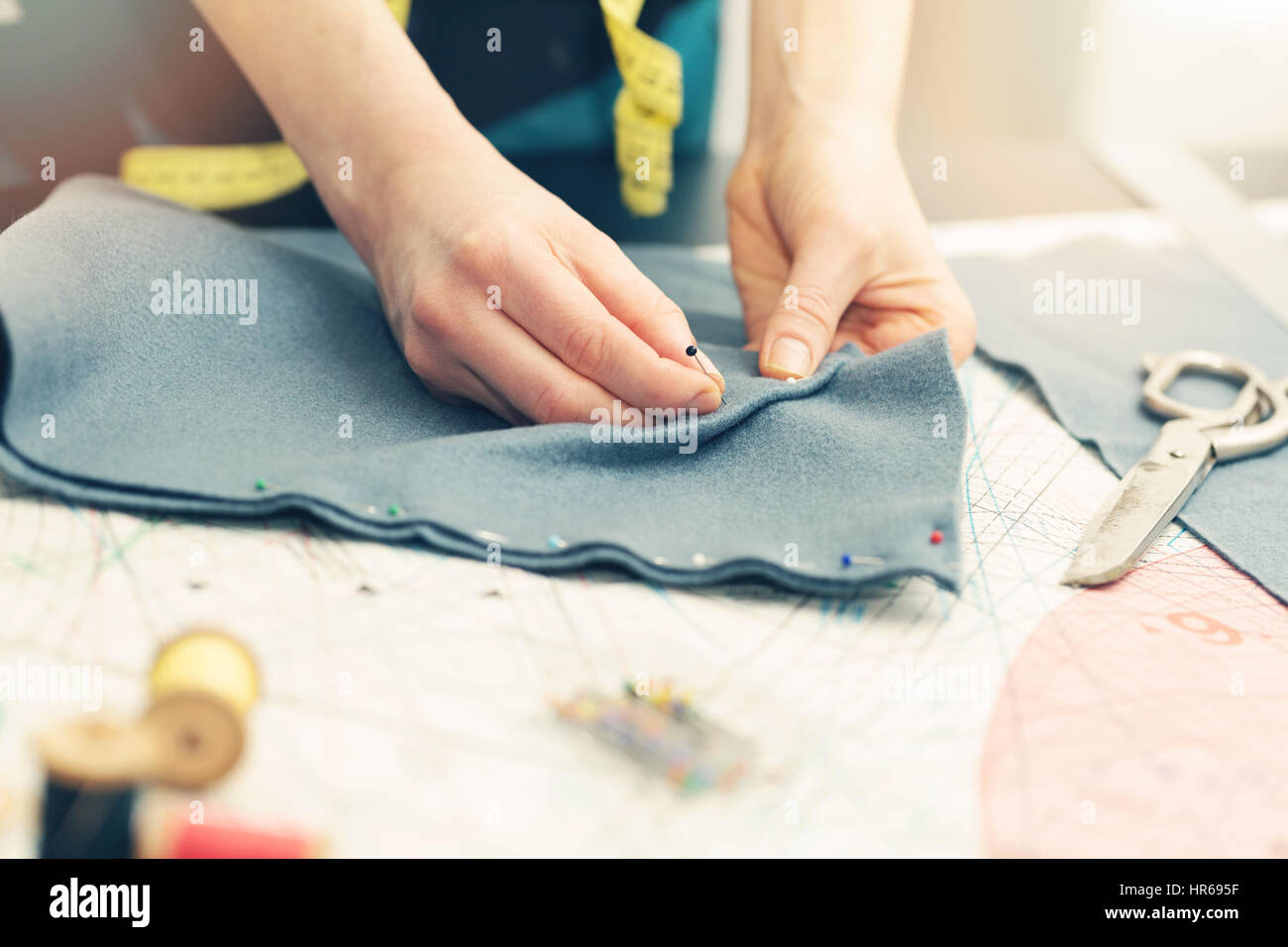 tailor marking the fabric with sewing pins Stock Photo