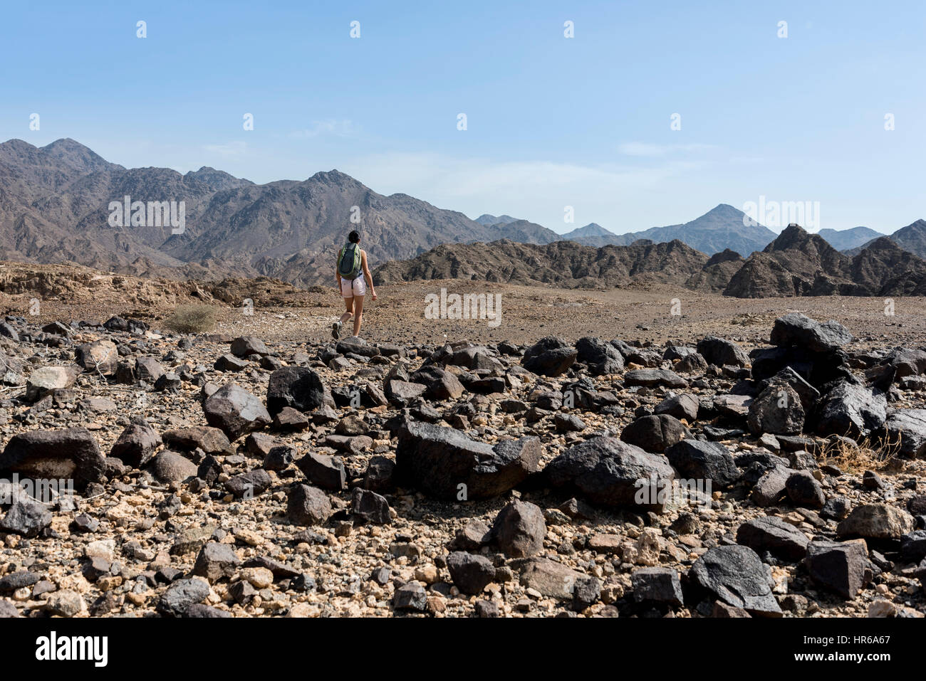 Woman trekking in a Wadi (Dry mountains) Stock Photo