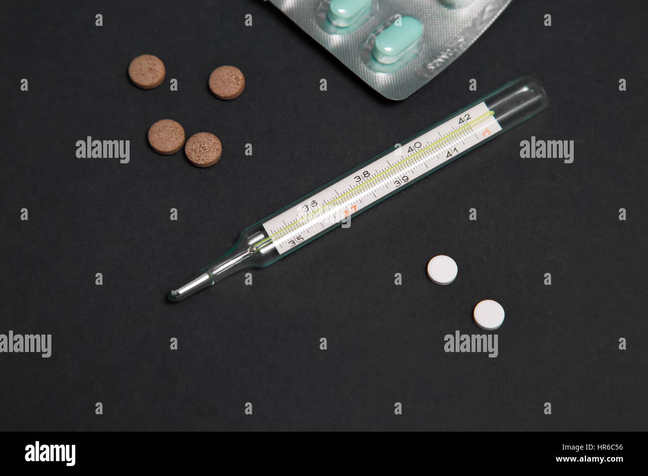 Bunch of blue pills with green injection in the background. Medical tools. Stock Photo