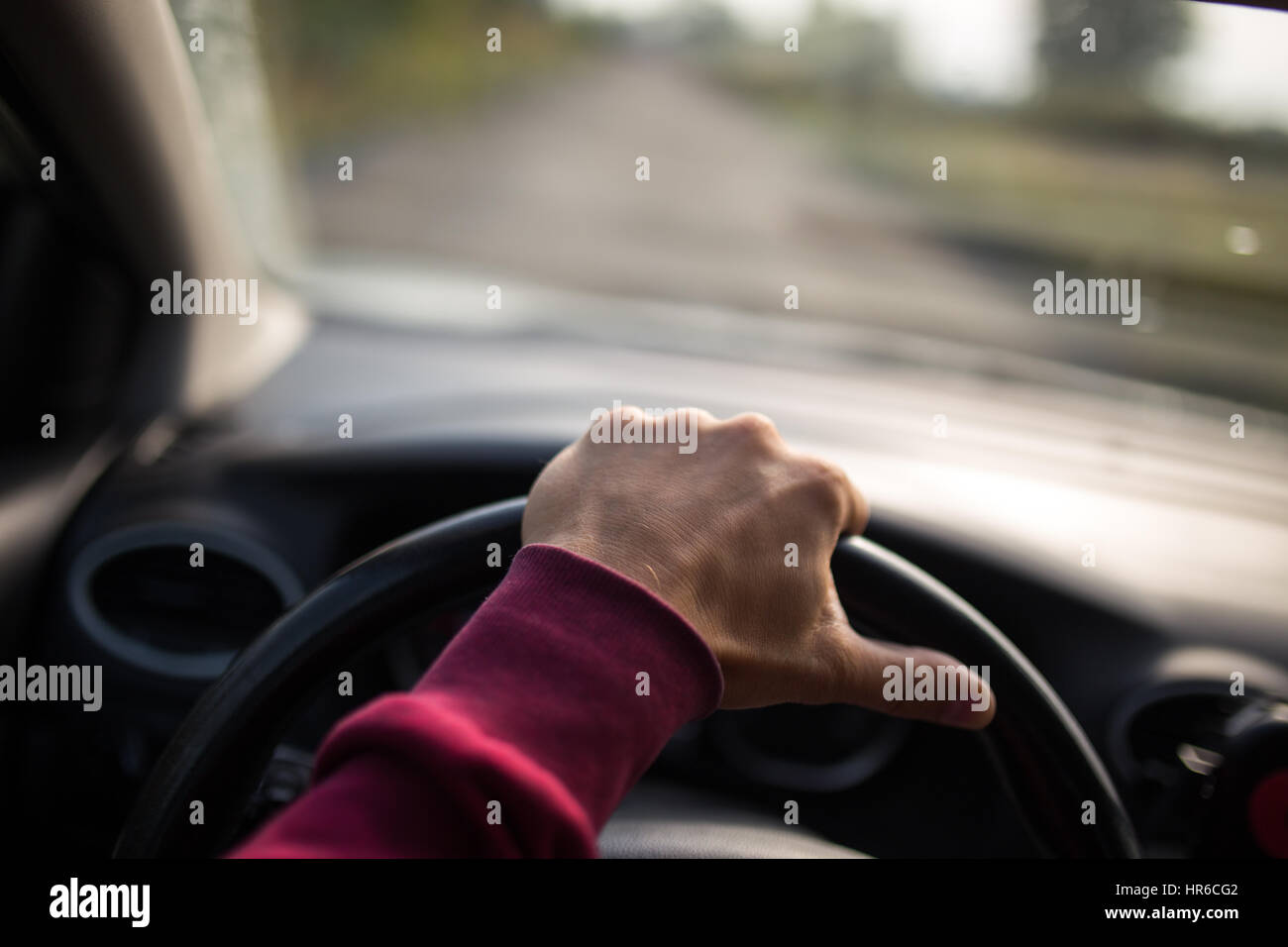Hand holding on black steering wheel while driving in the car Stock