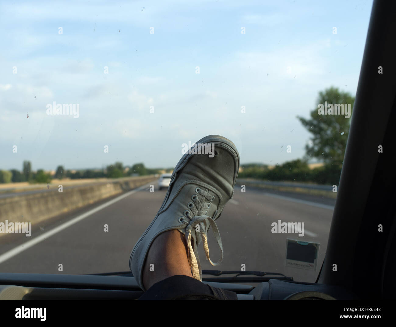 Vans Canvas shoe on the dashboard of a car speeding on a highway Stock Photo