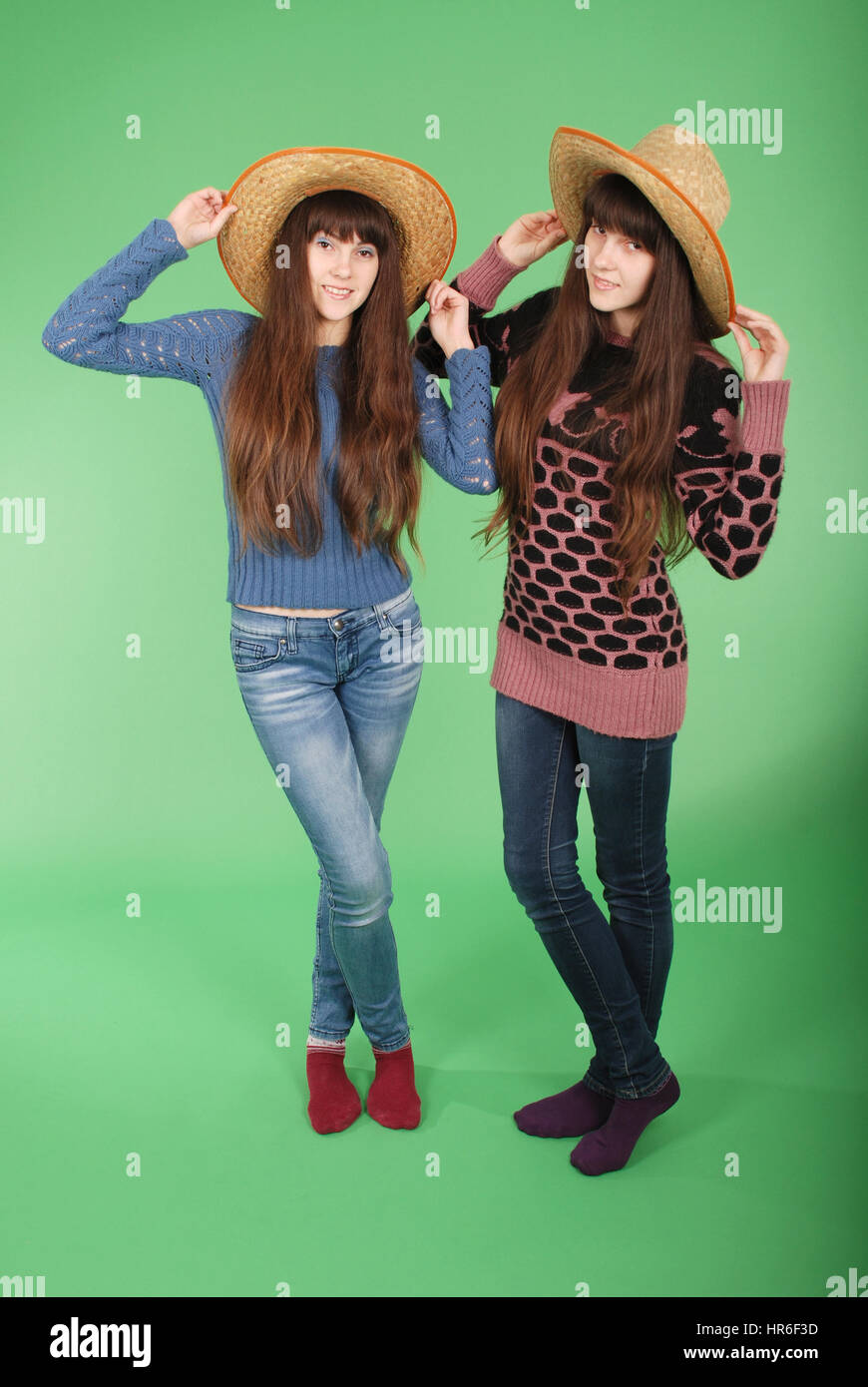 Beautiful two twins sisters on green background Stock Photo Alamy
