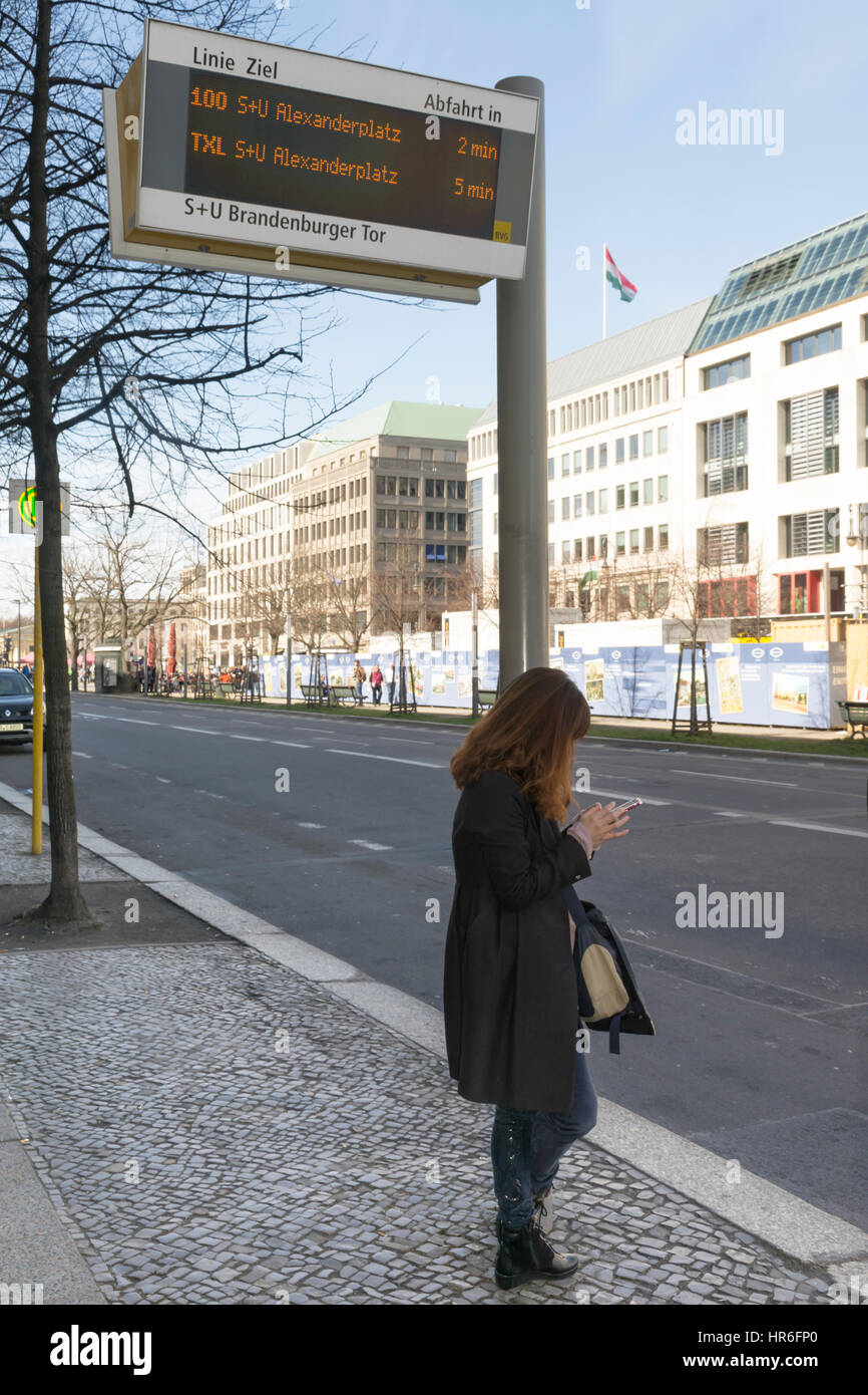 Woman waiting the bus at a bus stop near Brandenburg gate, Berlin, Germany Stock Photo