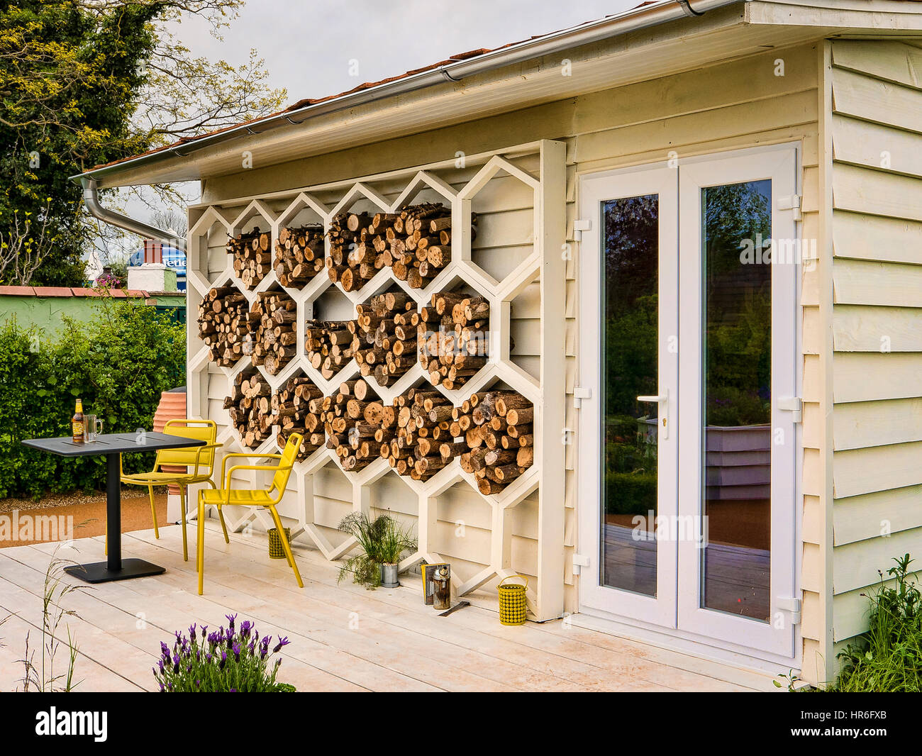 Display garden chalet at the Malvern Spring Flower Show featuring an innovative Bugs Hotel or wood store Stock Photo
