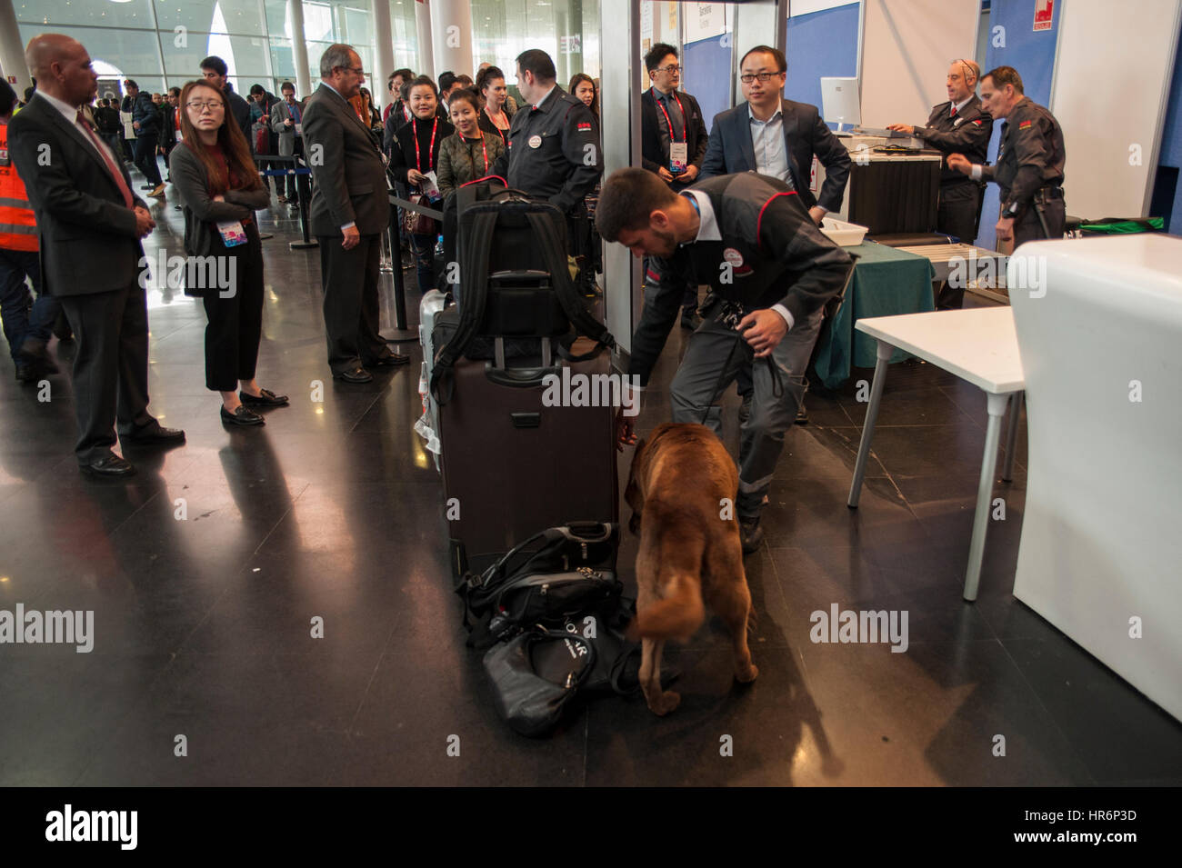 Barcelona, Spain. 27th Feb, 2017. Visitors wait to enter to the Mobile World Congress while a security guard checks with a police dog all the bundles that enter the interior. Credit: Charlie Perez/Alamy Live News Stock Photo
