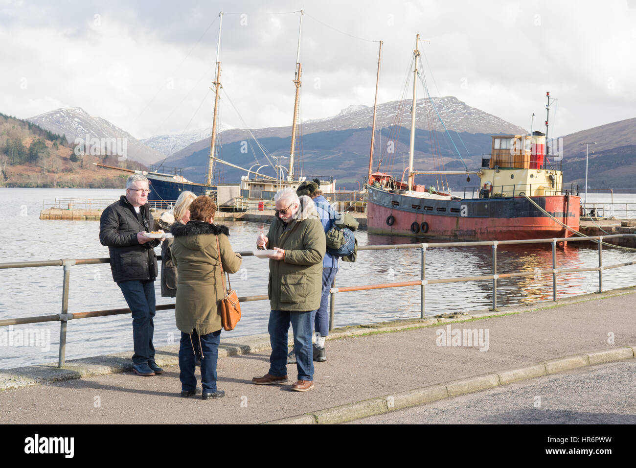 Inveraray, Argyll and Bute, Scotland, UK. 27th Feb, 2017. UK weather - eating traditional fish and chip suppers by Inveraray Harbour on a still bright day overlooking Loch Fyne Credit: Kay Roxby/Alamy Live News Stock Photo