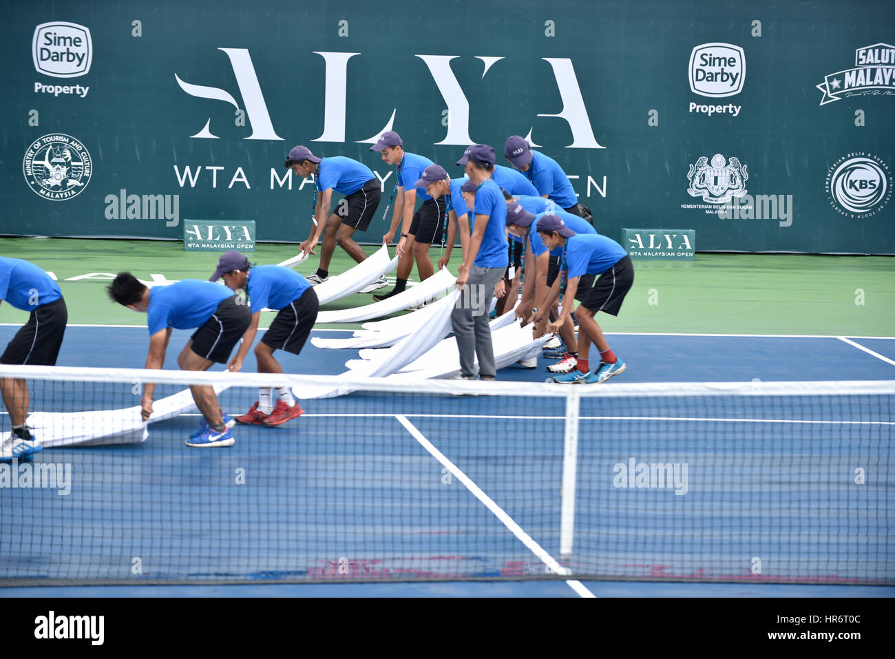 Kuala Lumpur, Malaysia. 27th Feb, 2017. Volunteers mopping tennis court due to heavy raining on