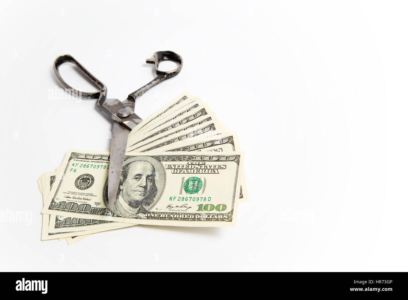 Scissors cuts dollars banknote on white background Stock Photo - Alamy