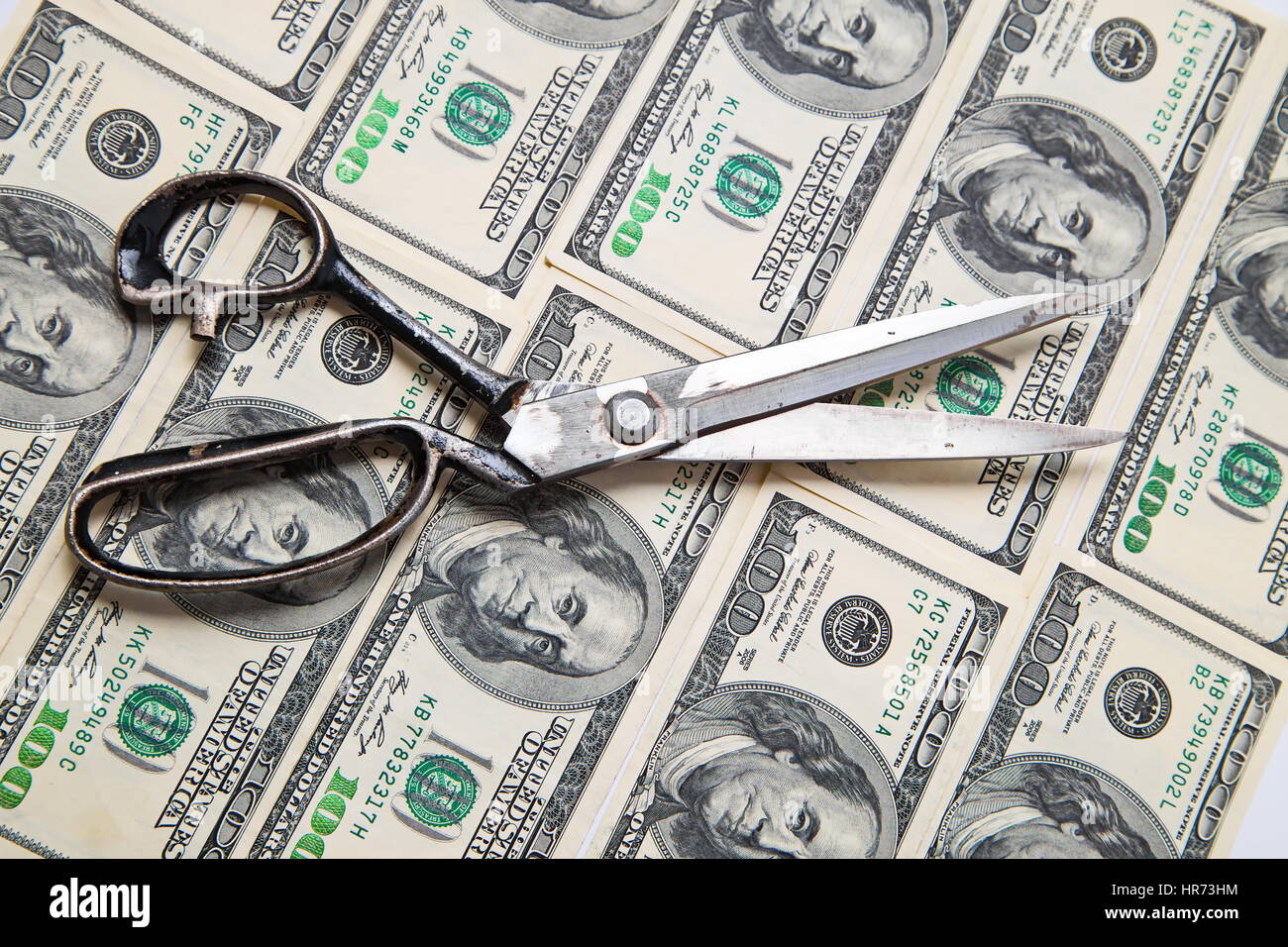 Scissors cuts dollars banknote on white background Stock Photo - Alamy