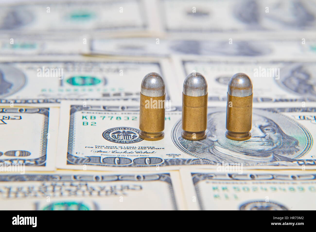 Bullets on dollar bills Stock Photo