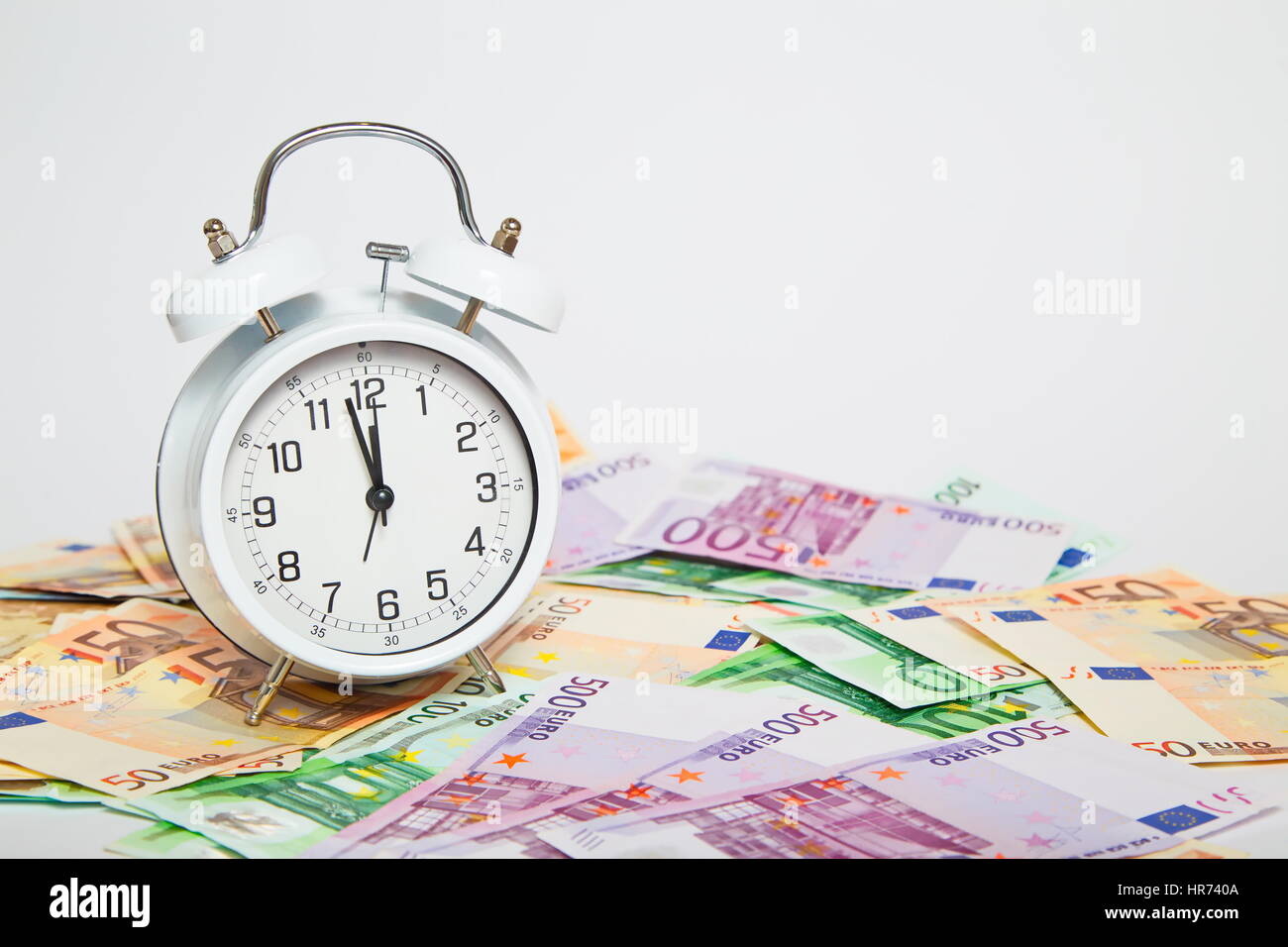 Old Alarm clock and euro paper currency Stock Photo