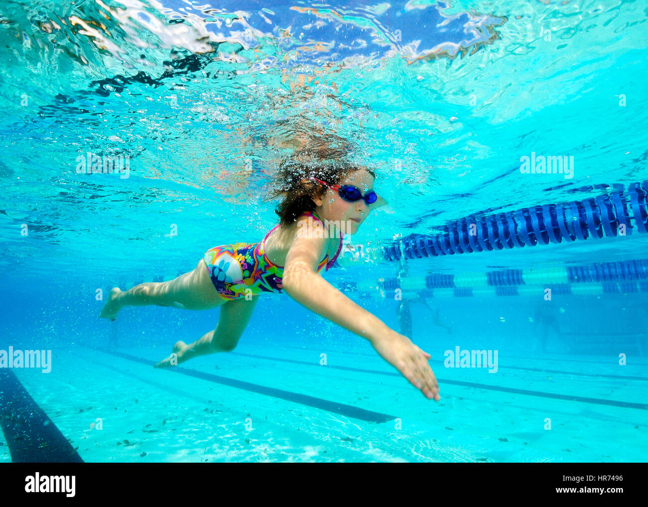 Kids swimming underwater in pool enjoying the relaxation of summer Stock Photo
