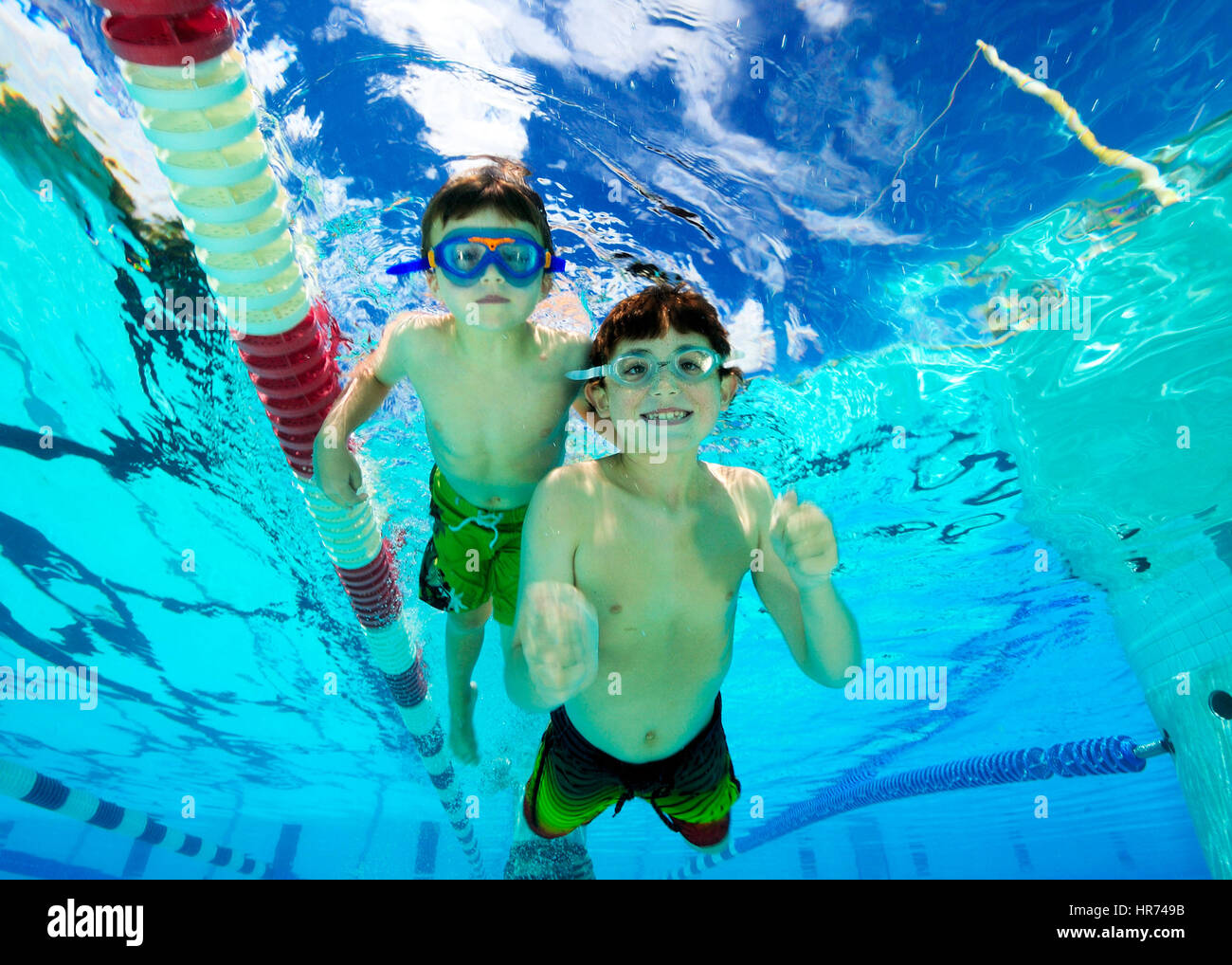 Kids swimming underwater in pool enjoying the relaxation of summer Stock Photo