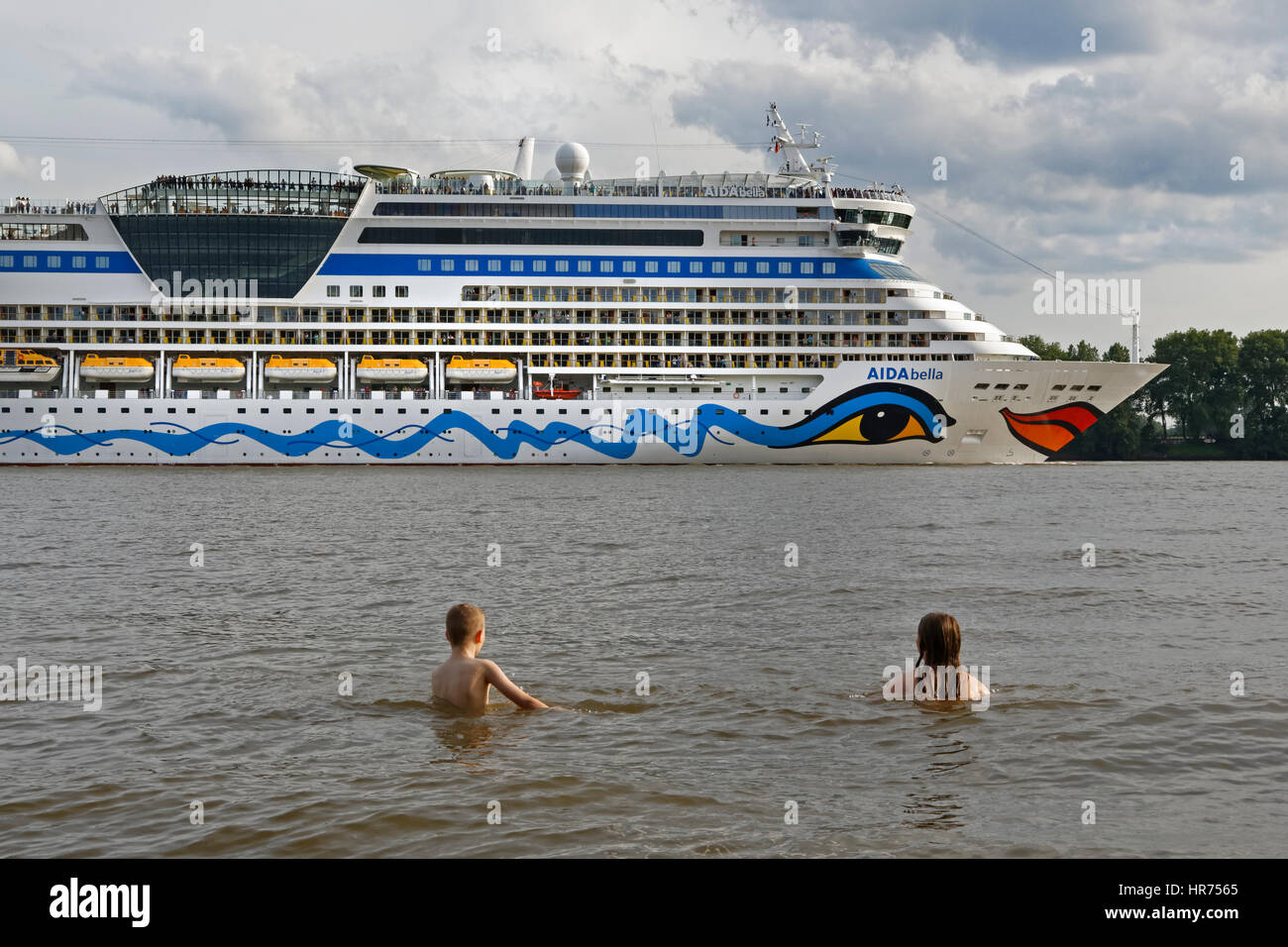 Two children swimming in  front of a cruise liner, Hamburg, Germany, Europe Stock Photo