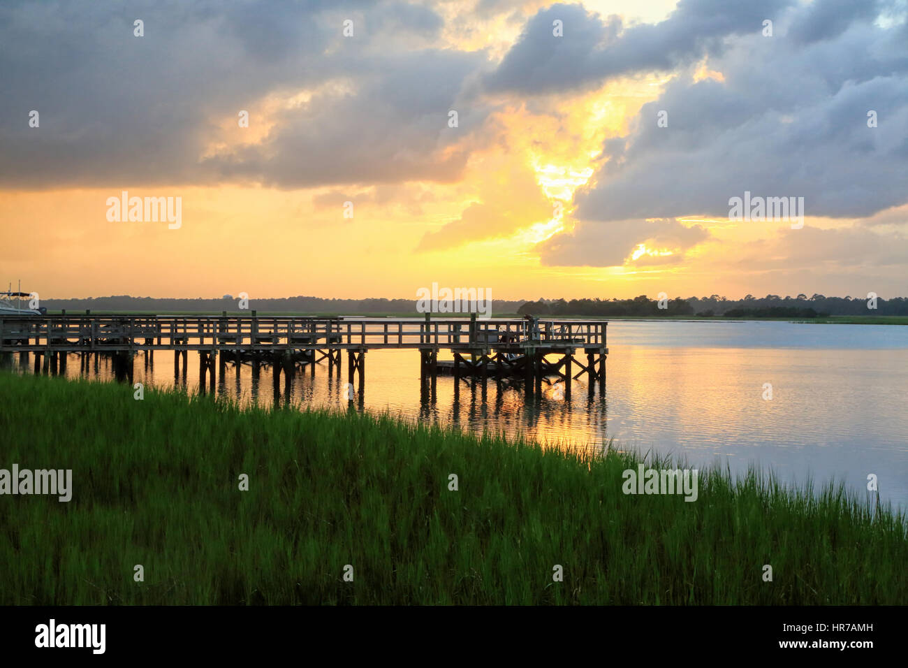Sunset over the Kiawah River on Kiawah Island, South Carolina. The silhouette of several piers is light with sunset light. Stock Photo