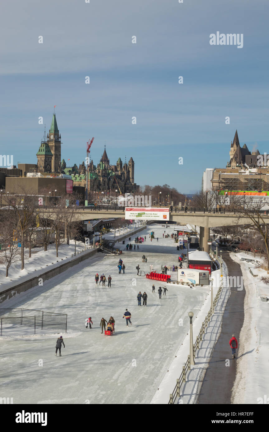 People ice skating on the frozen Rideau canal, Ottawa on a sunny day, during the annual Winterlude, bal de Neige winter festival. Stock Photo