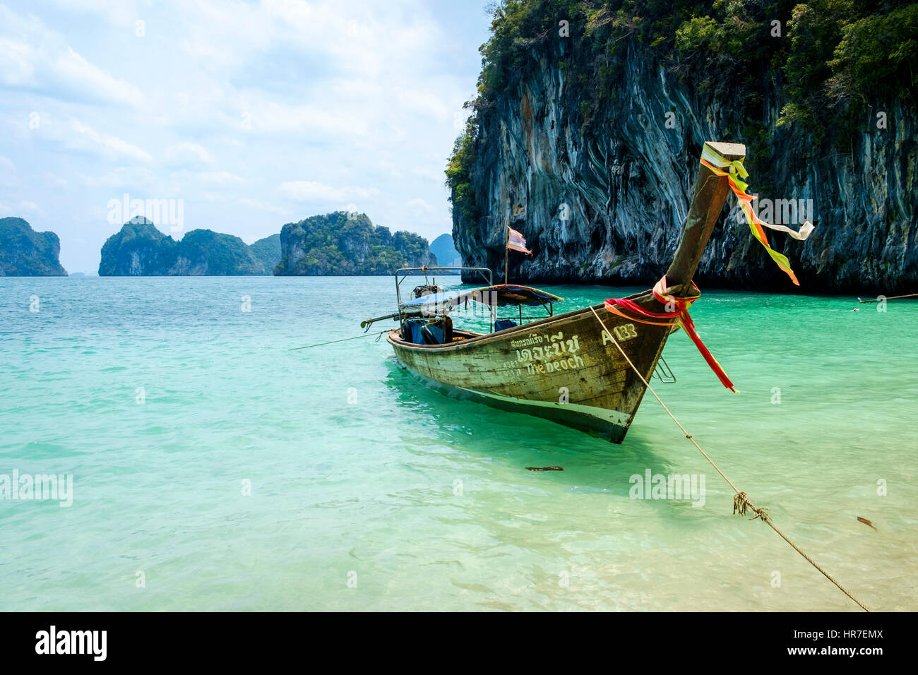 A Thai long-tail boat moored off the coast in the Krabi Province, Thailand. These boats are one of the main means of transportation in Thailand. Stock Photo