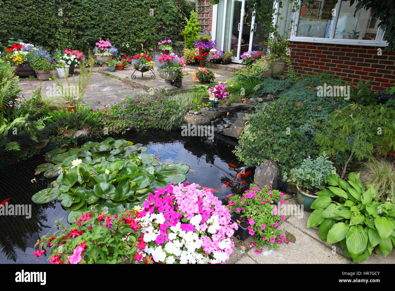 Pretty garden pond and patio in summer Stock Photo