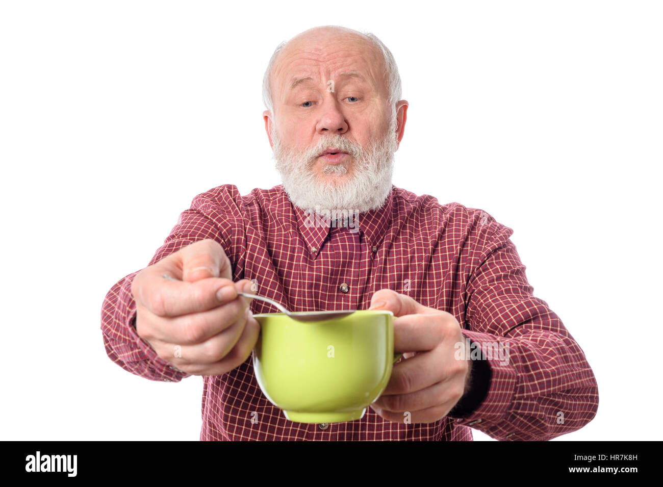 Cheerfull senior man with green cup and teaspoon, isolated on white Stock Photo