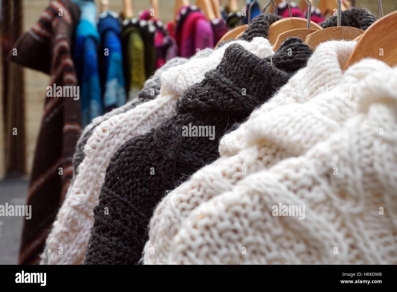 Black and white thick knitted wool winter jumpers and jackets for sale on a marlet stall Stock Photo