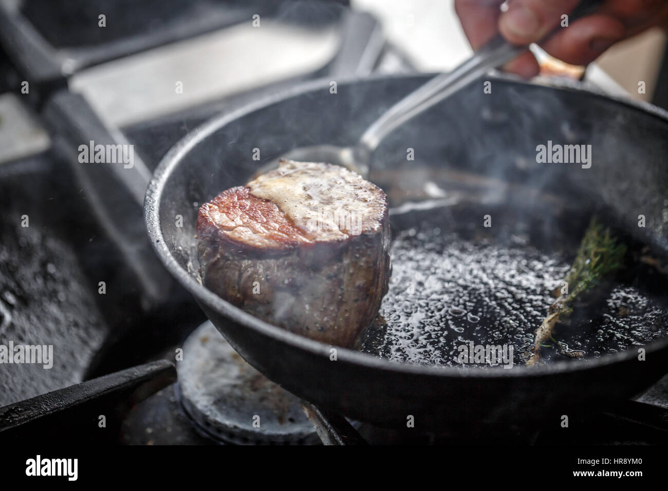 Piece of beef meat frying in the pan with butter Stock Photo
