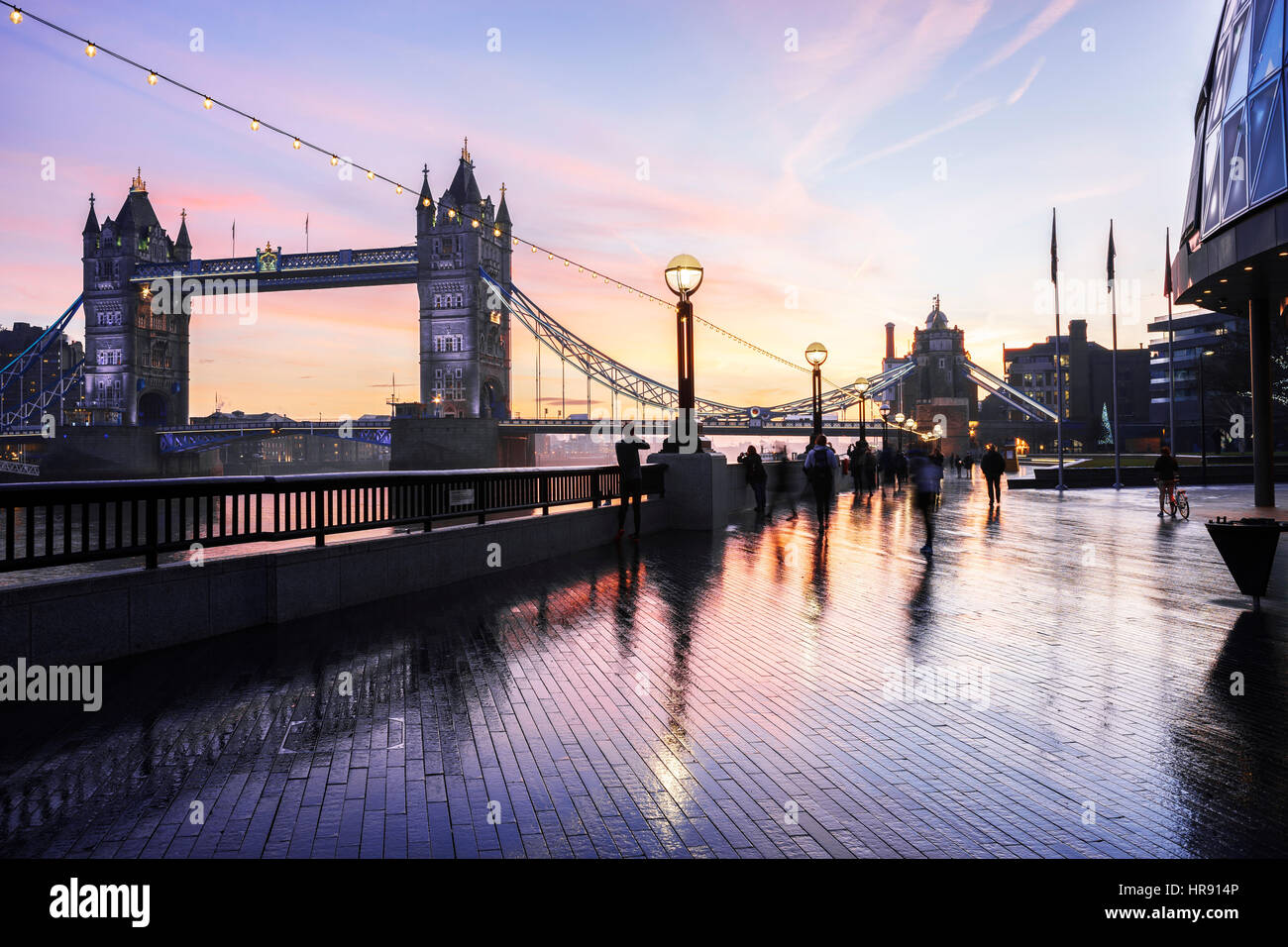 Tower Bridge and the bank of River Thames with blurred people, Southwark, London, UK Stock Photo