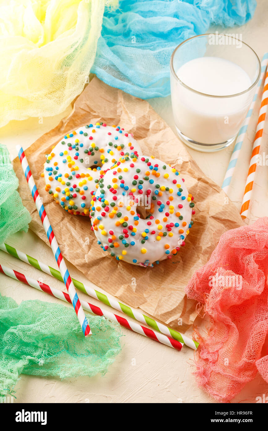Donuts with icing and milk on light colored background Stock Photo